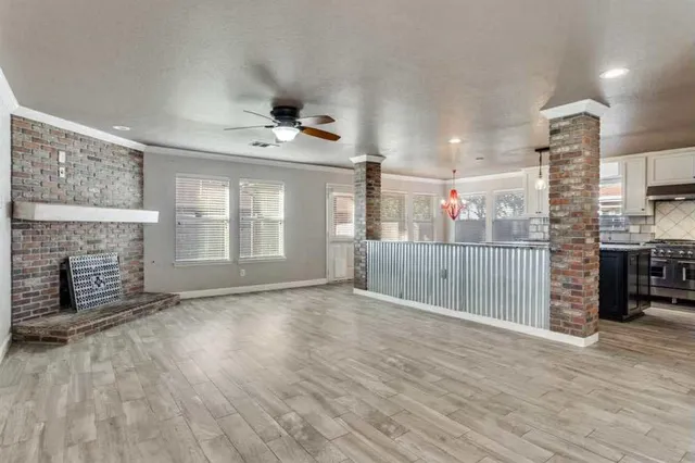 an empty room with wooden floor and a fireplace