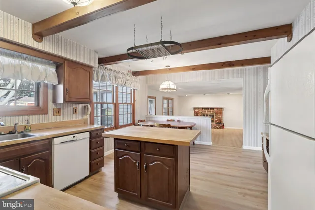 a kitchen with a sink stove cabinets and wooden floor