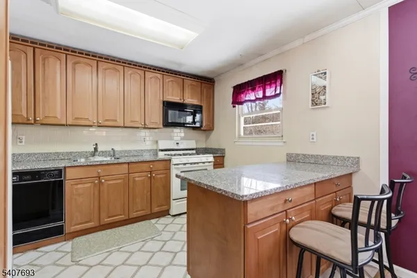 a kitchen with granite countertop a refrigerator and a sink
