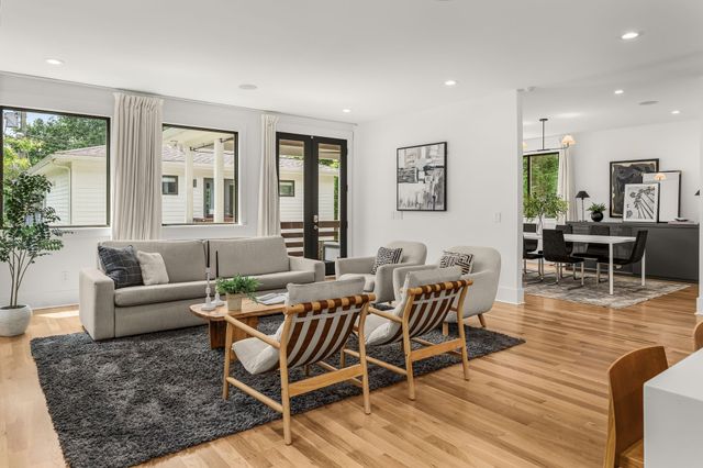 a living room with furniture wooden floor and a large window