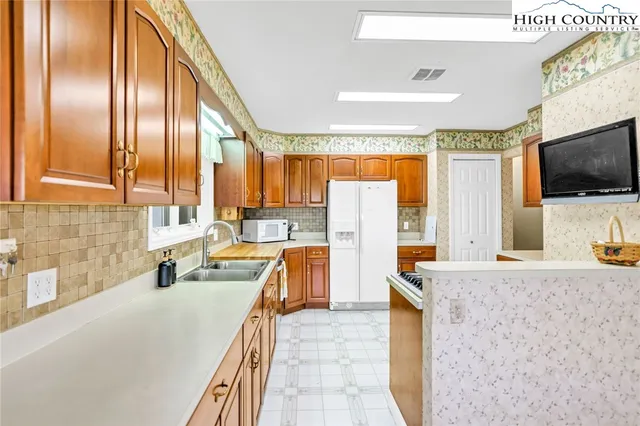 a large kitchen with a large window and stainless steel appliances