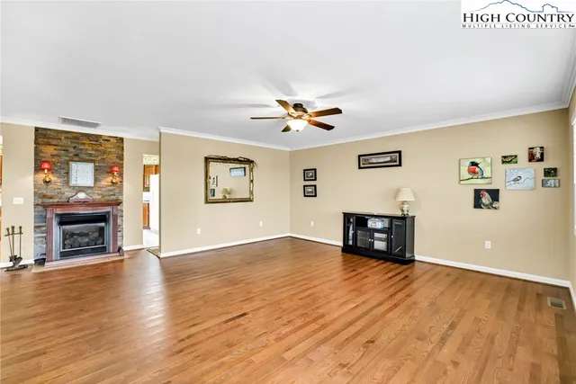 a view of an empty room with window and wooden floor