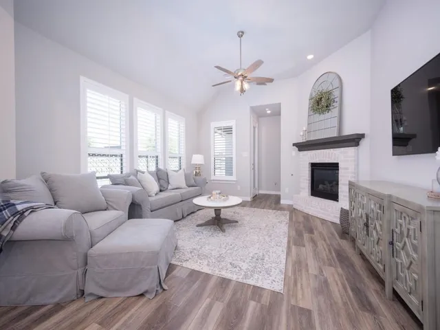 a living room with furniture a fireplace and a flat screen tv