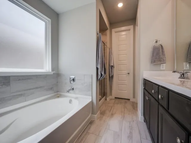 a spacious bathroom with a bathtub and a sink