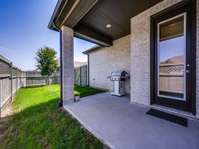 a view of a porch with a floor to ceiling window and garden