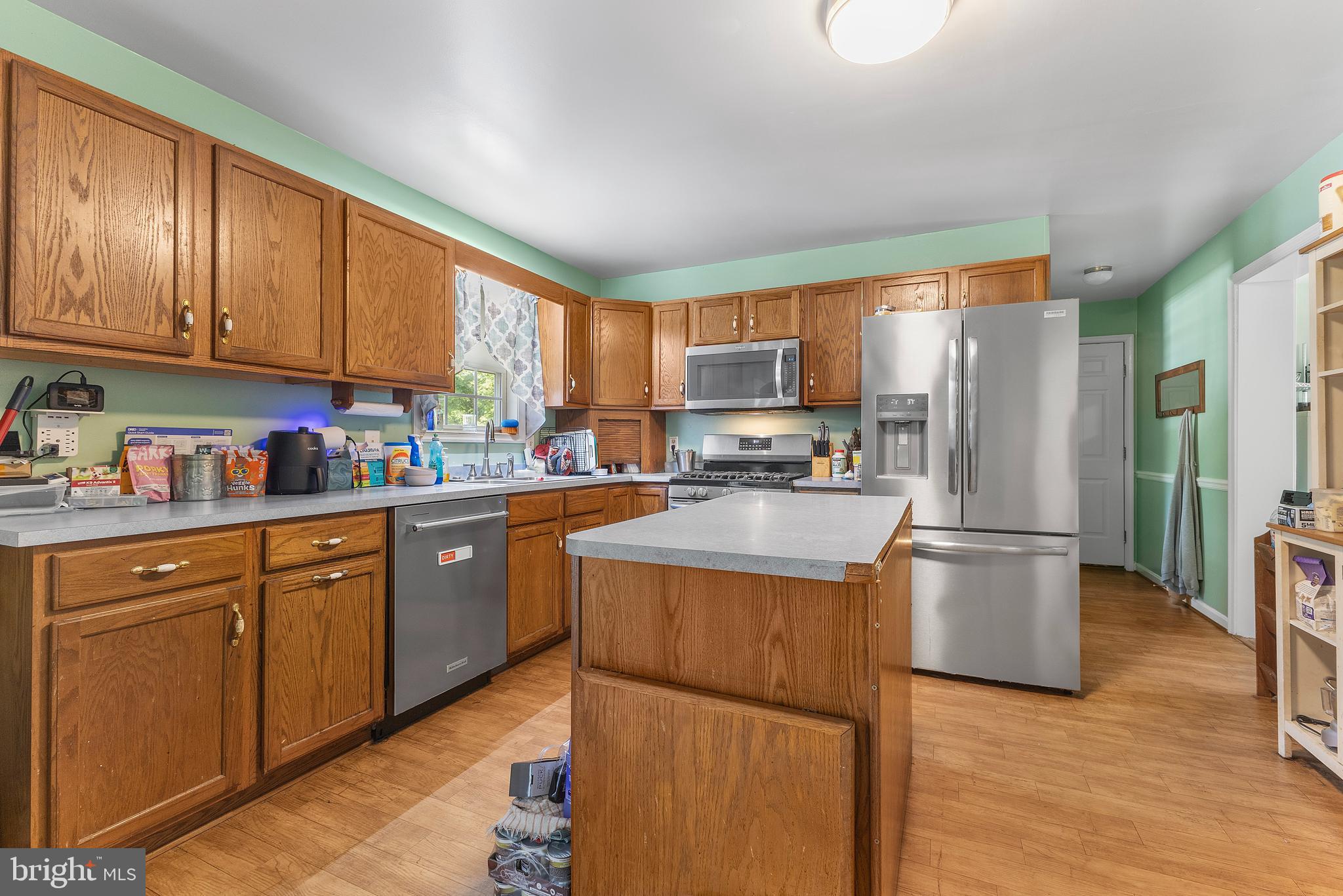 7112 East New Market Ellwood Road Hurlock, MD 21643 - Photo 9 of 41 a kitchen with stainless steel appliances granite countertop a refrigerator a sink dishwasher a stove top oven a refrigerator and cabinets with wooden floor