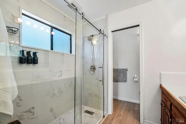 a bathroom with a granite countertop sink a mirror and a shower