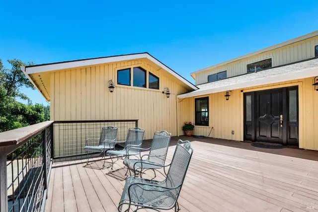 a view of a patio with table and chairs with wooden floor and fence