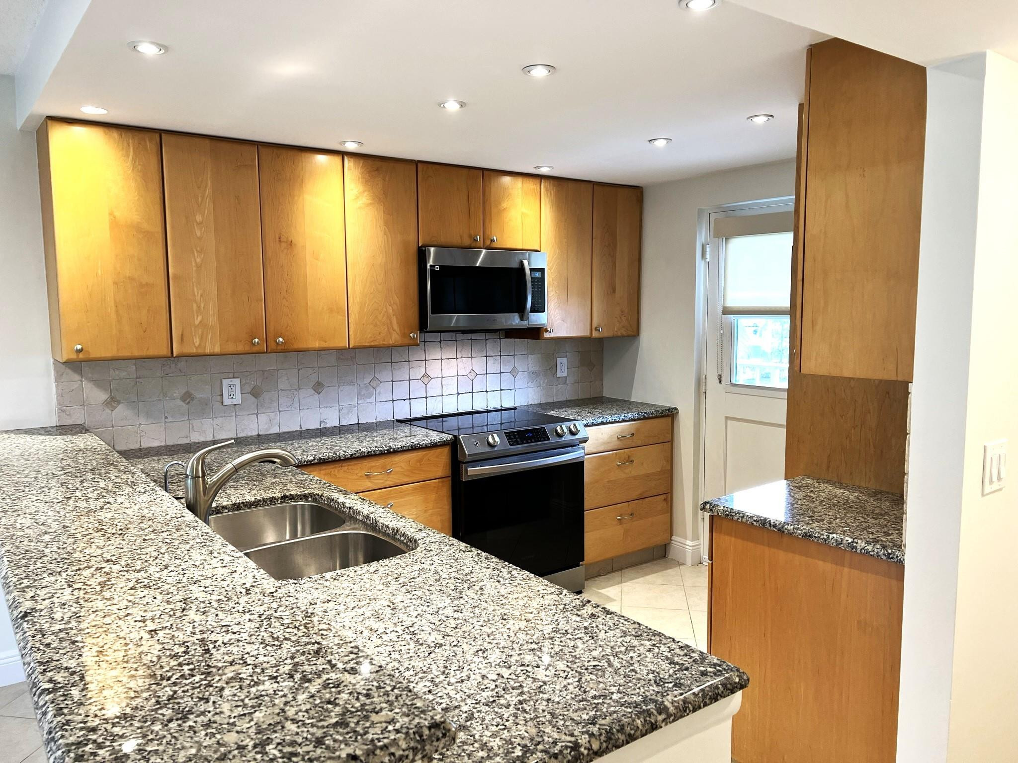 5700 Northwest 2nd Avenue, Unit 204 Boca Raton, FL 33487 - Photo 1 of 31 a kitchen with a stove a sink and a microwave
