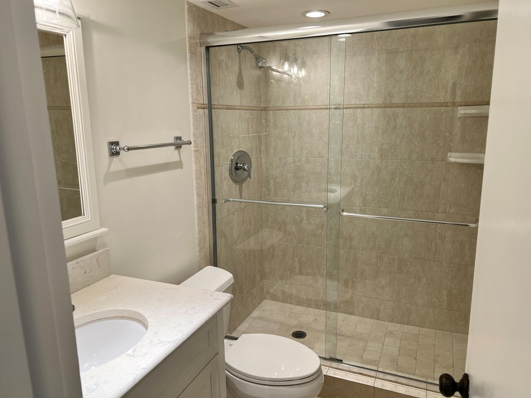 5700 Northwest 2nd Avenue, Unit 204 Boca Raton, FL 33487 - Photo 16 of 31 a white toilet sitting next to a bath tub and a shower