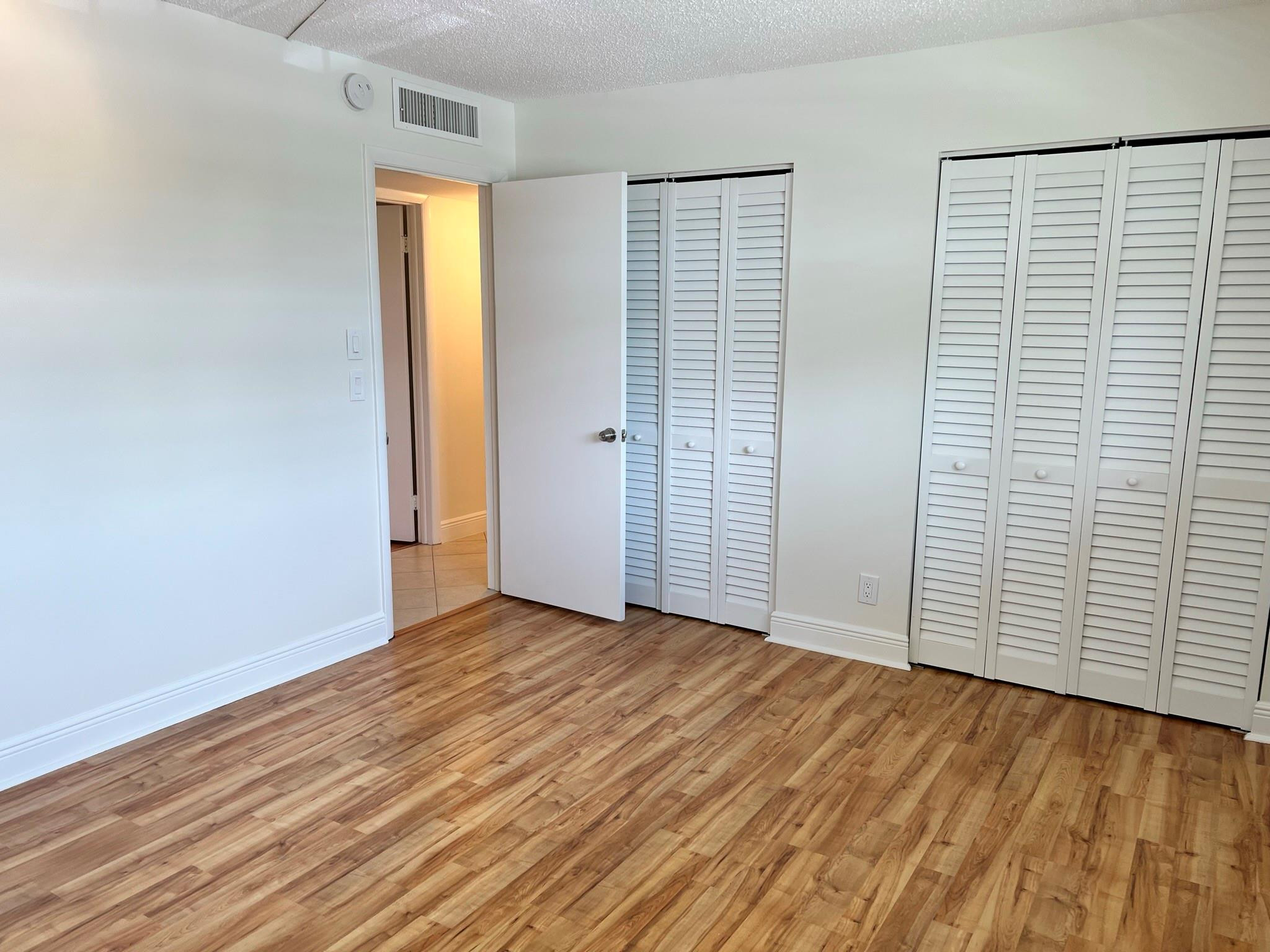 5700 Northwest 2nd Avenue, Unit 204 Boca Raton, FL 33487 - Photo 19 of 31 an empty room with wooden floor and closet