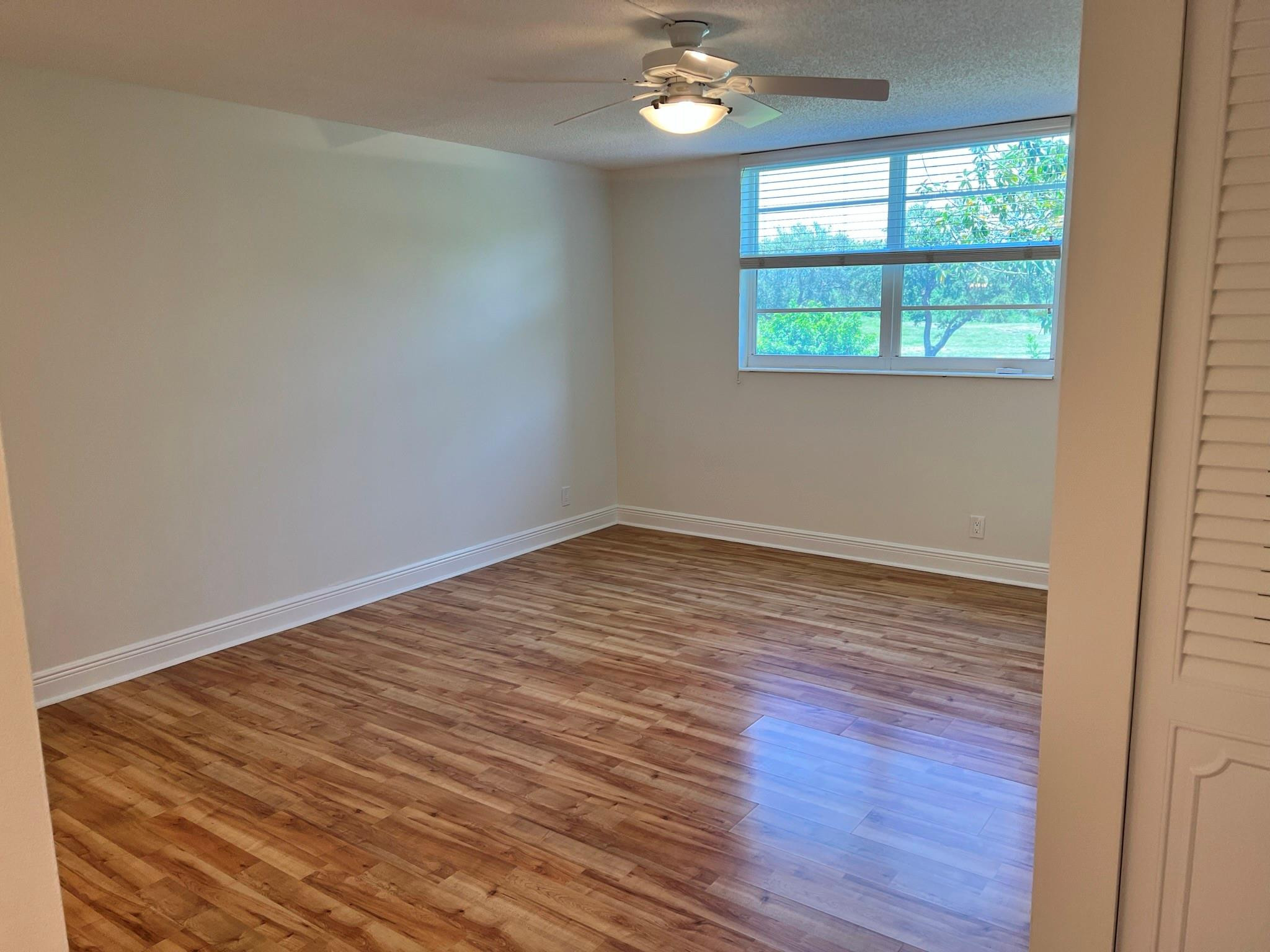 5700 Northwest 2nd Avenue, Unit 204 Boca Raton, FL 33487 - Photo 20 of 31 a view of an empty room with wooden floor and a window