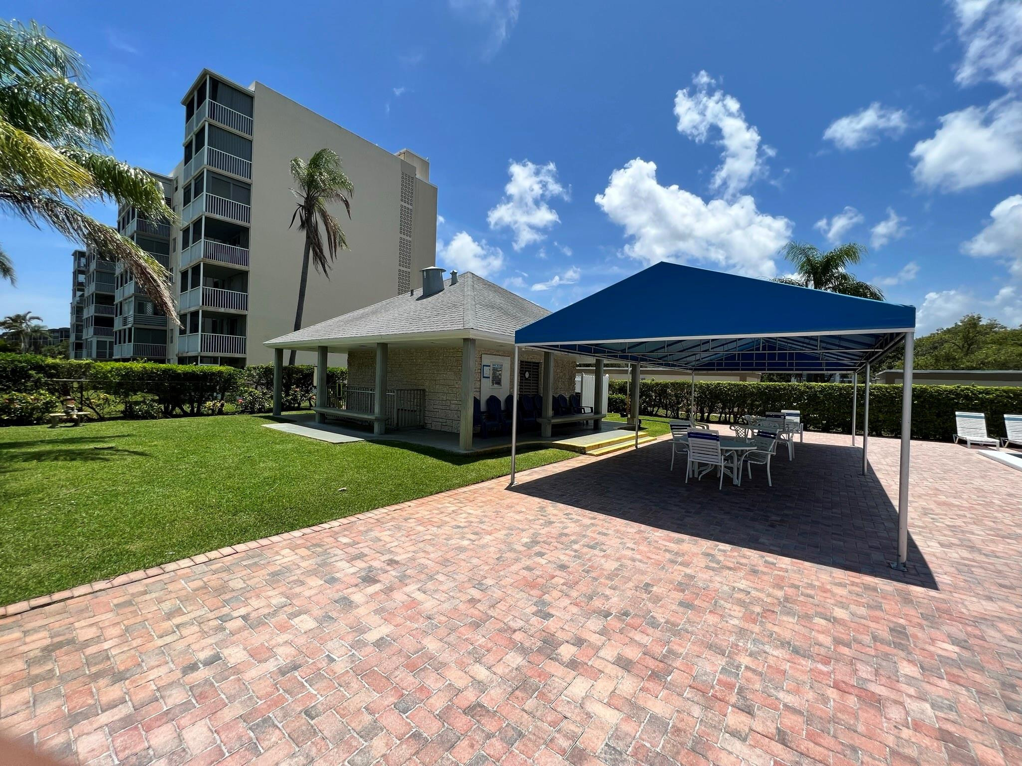 5700 Northwest 2nd Avenue, Unit 204 Boca Raton, FL 33487 - Photo 28 of 31 a patio with a table and chairs under an umbrella