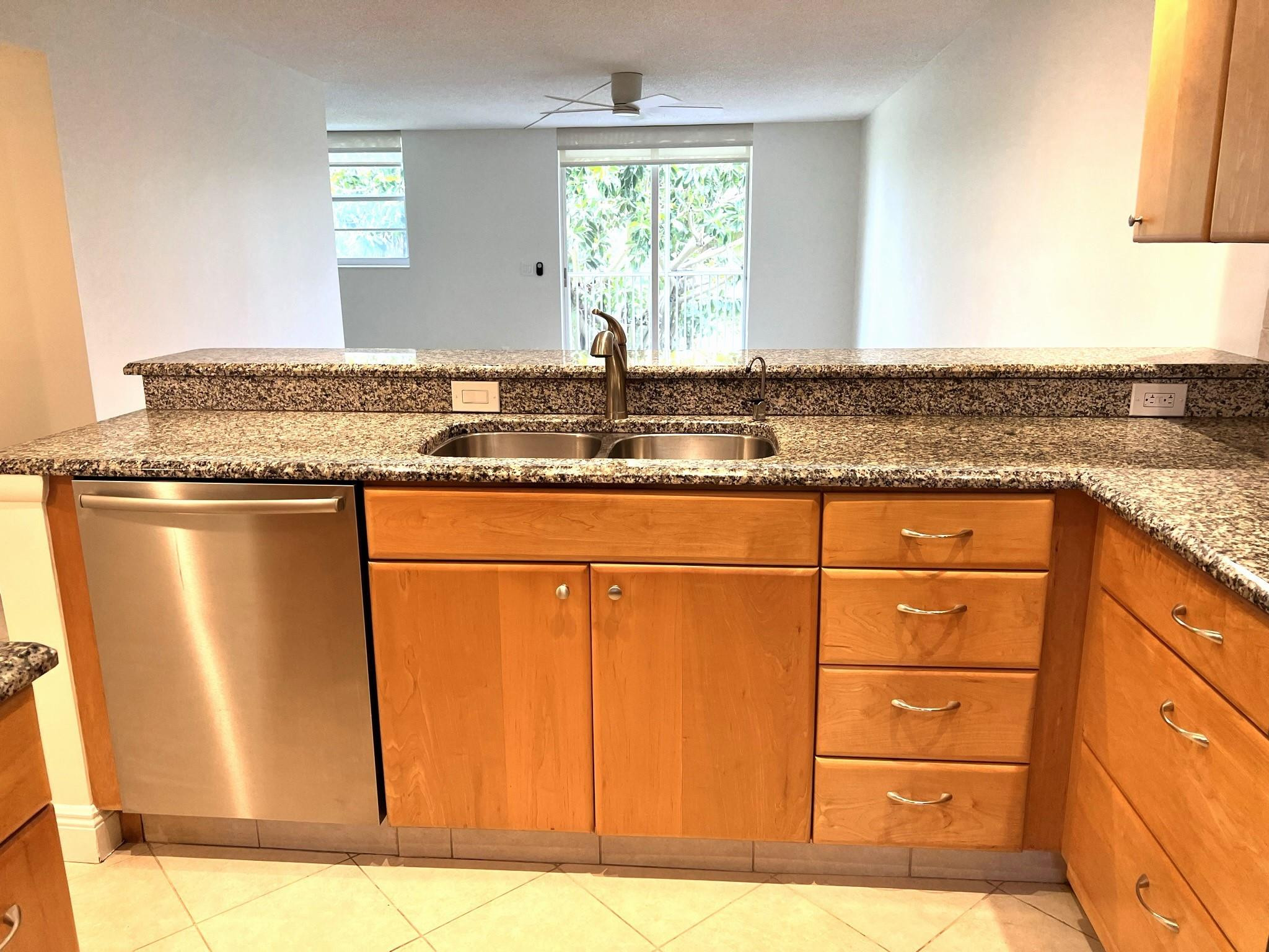 5700 Northwest 2nd Avenue, Unit 204 Boca Raton, FL 33487 - Photo 3 of 31 a kitchen with granite countertop cabinets and window