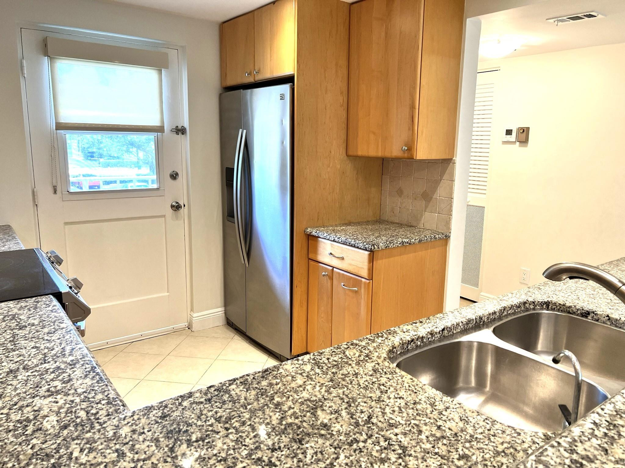 5700 Northwest 2nd Avenue, Unit 204 Boca Raton, FL 33487 - Photo 5 of 31 a kitchen with a refrigerator sink and cabinets
