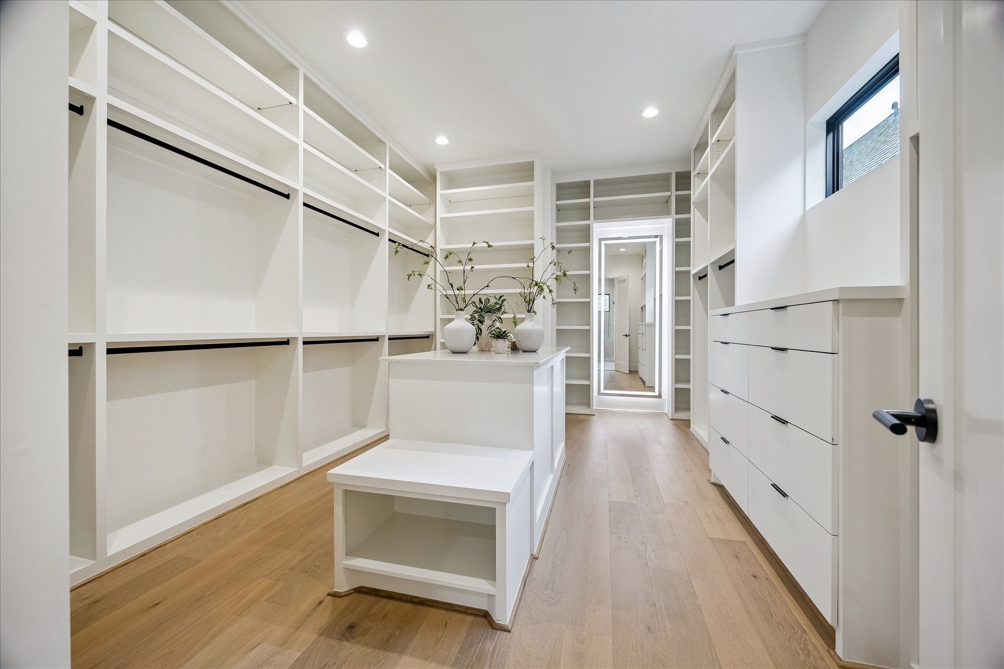 122 East 4th Street Houston, TX 77007 - Photo 24 of 38 Primary closet – offers custom built-ins including an island, drawers, and a full-length mirror with back lighting.