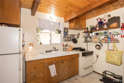 a view of a kitchen with fridge and workspace