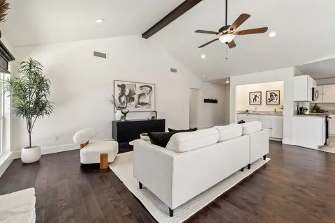 a kitchen with stainless steel appliances granite countertop a sink a stove a refrigerator and white cabinets