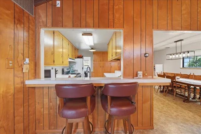 a kitchen with a sink and chairs