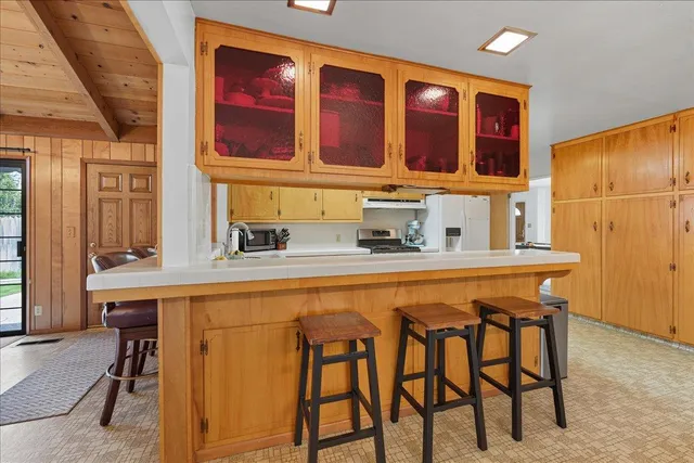 a kitchen with a table chairs sink and cabinets
