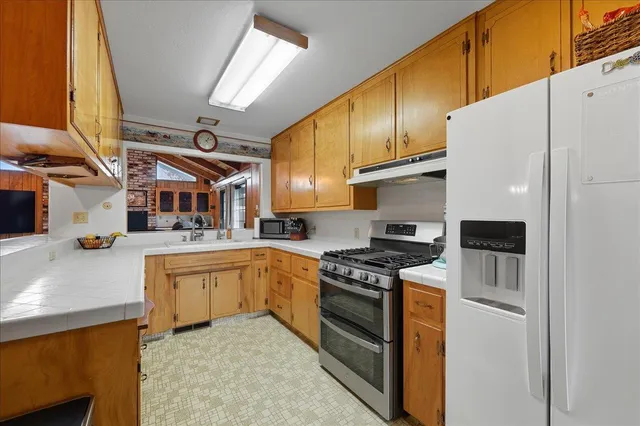 a kitchen with stainless steel appliances granite countertop a stove sink and refrigerator