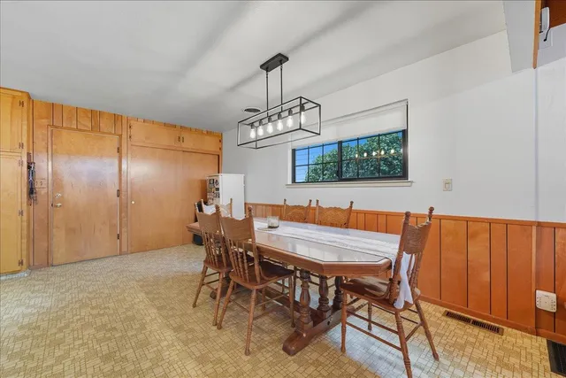 a dining room with furniture a chandelier and window