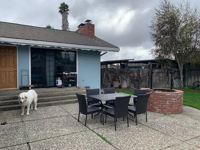 a view of house with backyard and outdoor seating