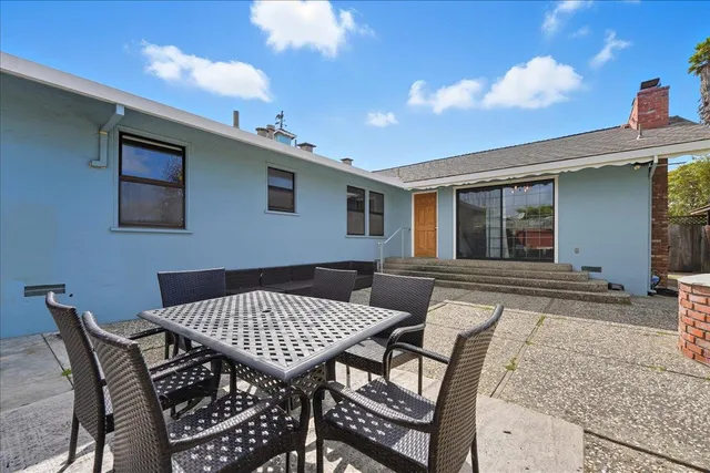 a backyard of a house with table and chairs