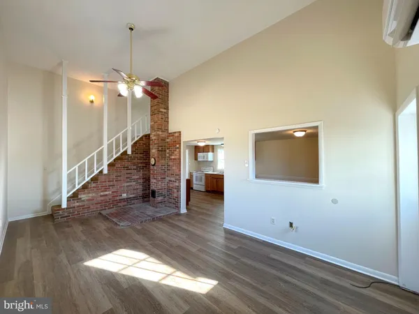 a view of a livingroom with wooden floor and a ceiling fan