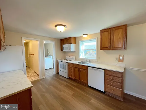 a kitchen with granite countertop a sink cabinets and stainless steel appliances