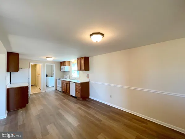 a large white kitchen with a sink and dishwasher a oven with wooden floor