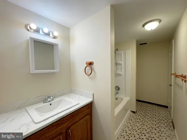 a bathroom with a sink a shower a mirror and a toilet