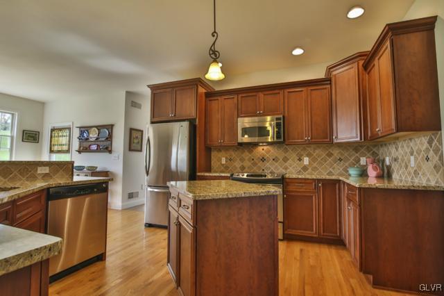 297 Meyer Road Nazareth, PA 18064 - Photo 15 of 41 a kitchen with stainless steel appliances granite countertop a refrigerator a sink dishwasher a stove with wooden cabinets and floor