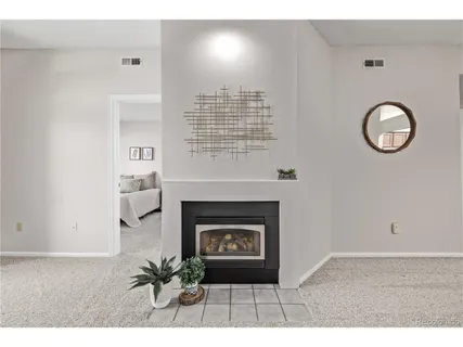a view of an empty room with a fireplace and a window