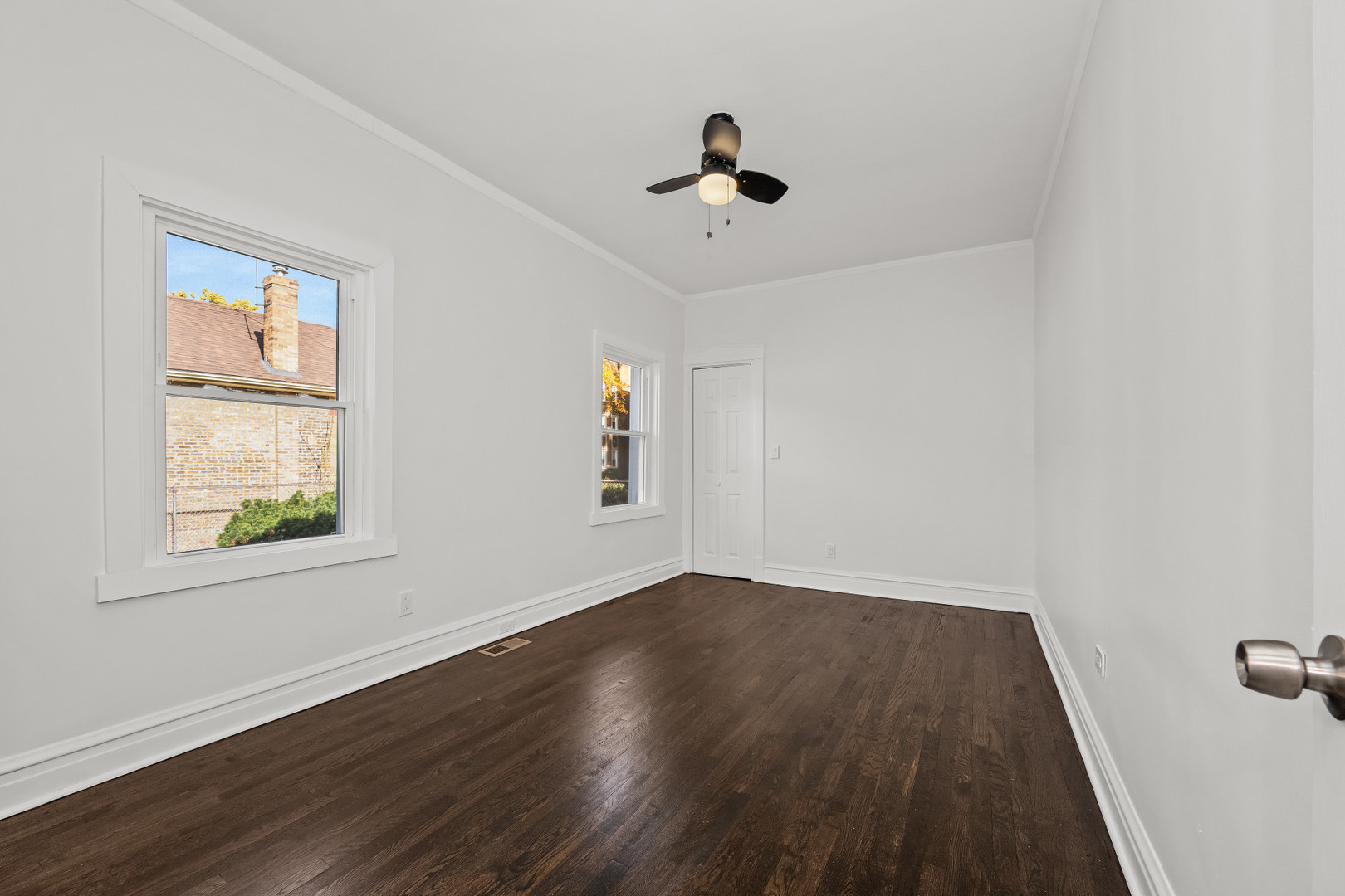 7832 South Paxton Avenue Chicago, IL 60649 - Photo 39 of 59 a view of an empty room with wooden floor and a window