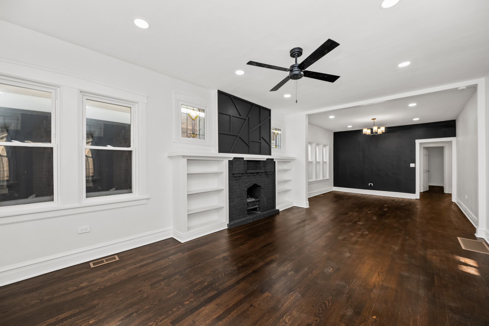 7832 South Paxton Avenue Chicago, IL 60649 - Photo 4 of 59 a view of a livingroom with a fireplace a ceiling fan and wooden floor