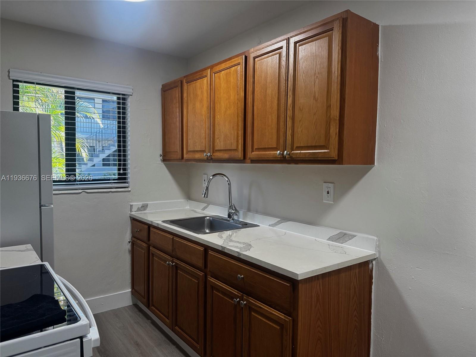 1310 West 29th Street, Unit 6 Hialeah, FL 33012 - Photo 6 of 15 a kitchen with a sink cabinets and window