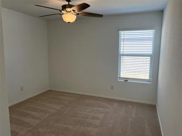 a room with a fan and cabinets