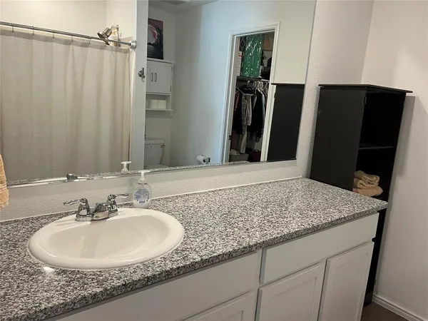 a bedroom with a bed and a flat tv screen on dresser