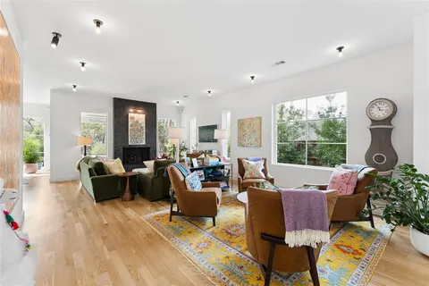 a living room with furniture a fireplace and a large window