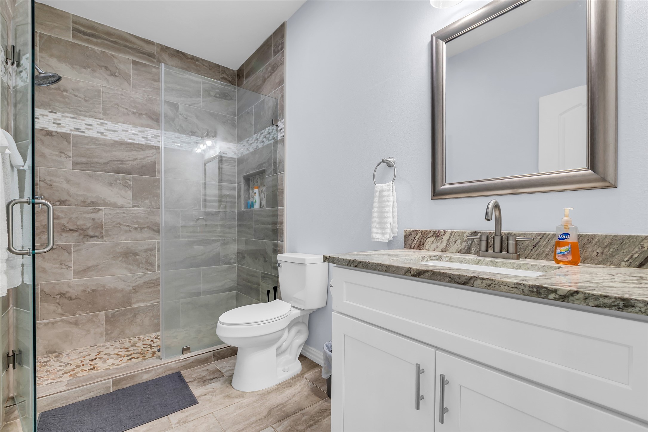 197 Rain Forest Road Onalaska, TX 77360 - Photo 16 of 25 a bathroom with a granite countertop sink a toilet a mirror and shower