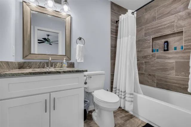 a bathroom with a granite countertop sink toilet and shower
