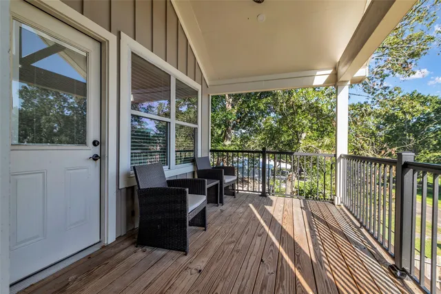 a view of a balcony with chairs and wooden floor
