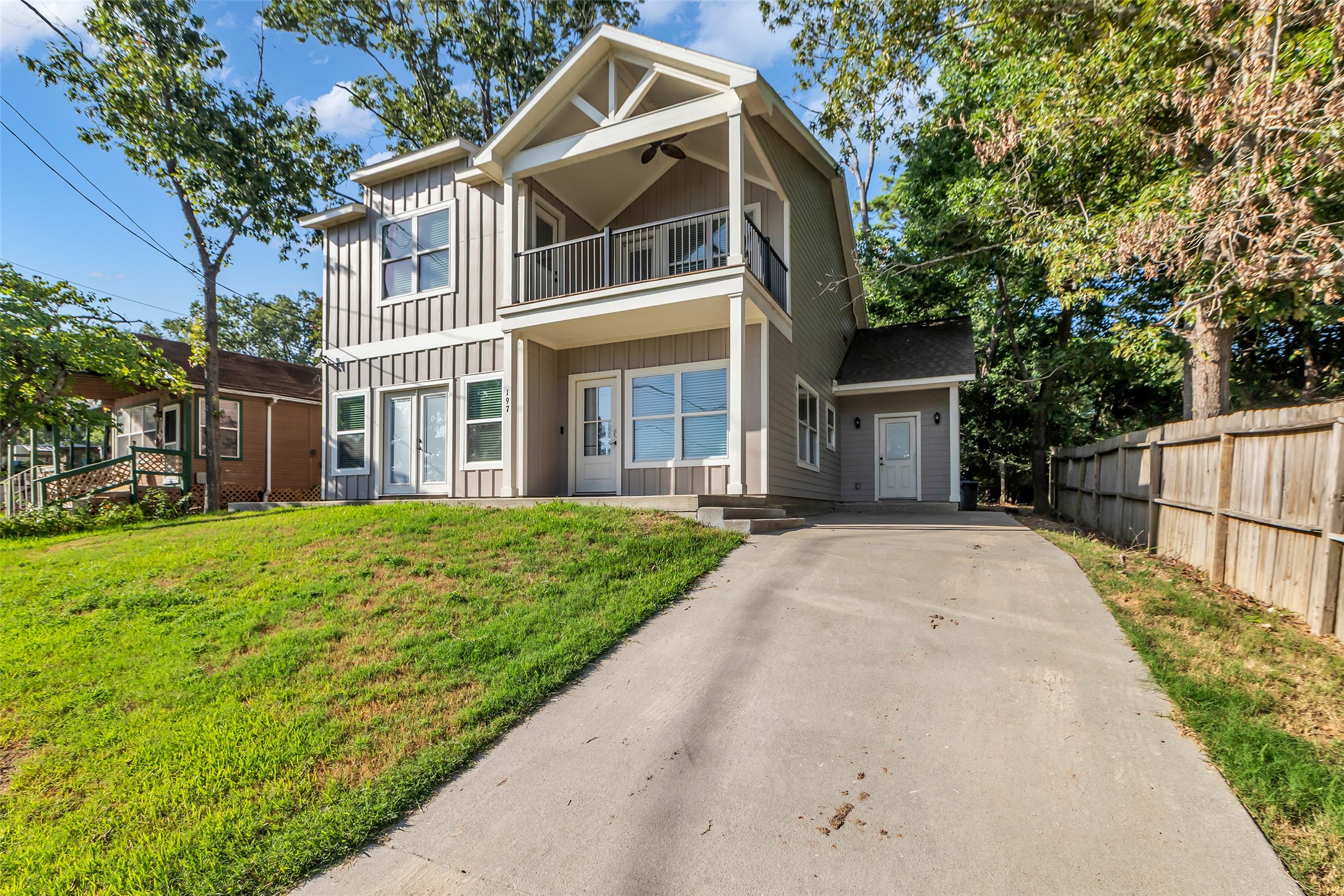 197 Rain Forest Road Onalaska, TX 77360 - Photo 24 of 25 a view of a white house with large windows and a small yard