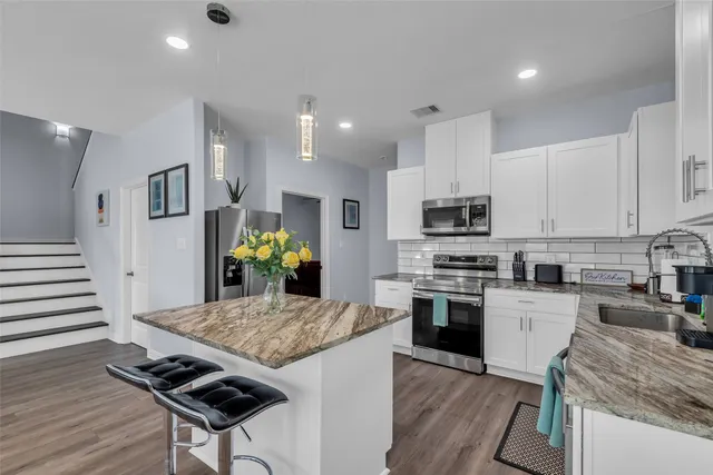 a kitchen with kitchen island granite countertop stainless steel appliances cabinets a stove and center island