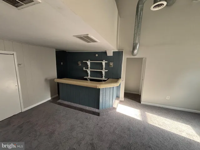 a view of an empty room with kitchen