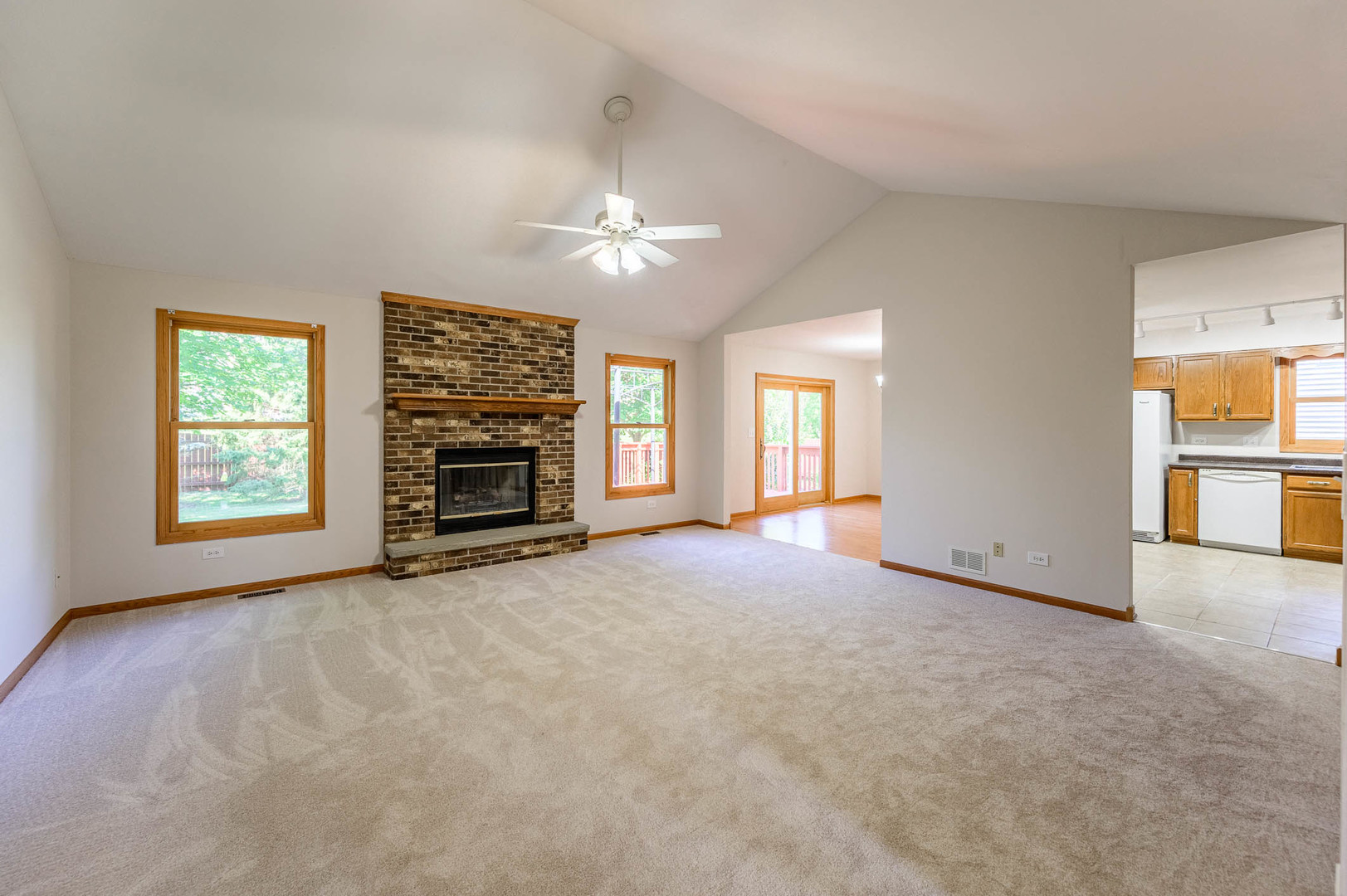638 Colony Avenue Lindenhurst, IL 60046 - Photo 2 of 15 an empty room with windows fireplace and a kitchen view