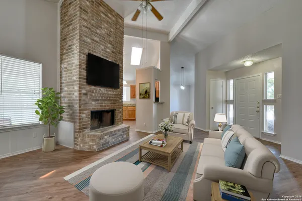 a living room with furniture a flat screen tv and a fireplace