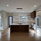 a large kitchen with stainless steel appliances granite countertop a lot of counter space and wooden floor