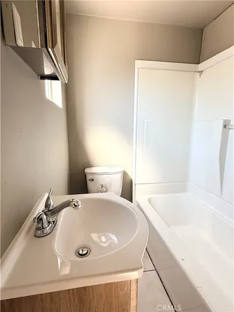 a spacious bathroom with a granite countertop sink a mirror and a bathtub